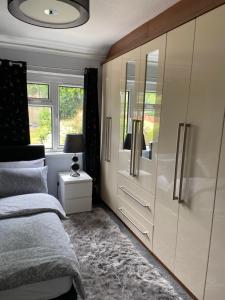 1 dormitorio con 1 cama y vestidor con espejo en Aylesbury Manor, en Birmingham