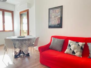 ein Wohnzimmer mit einem roten Sofa und einem Tisch in der Unterkunft L'IPPOCASTANO Appartamenti - B&B in Castellaneta