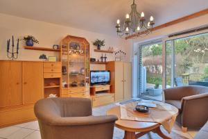 a living room with a table and chairs and a tv at Strandschlößchen Strandschlösschen Appartement 3 in Haffkrug