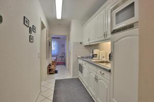 a kitchen with white cabinets and a sink at Strandschlößchen Strandschlösschen Appartement 3 in Haffkrug