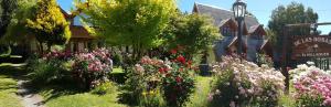 a garden of flowers in front of a building at De las Rosas Bariloche in San Carlos de Bariloche