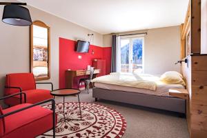 a hotel room with a bed and a chair at Hôtel du Glacier in Champex