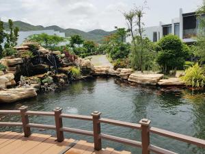 a pond in a garden next to a building at Villa Biển - Oceanami Resort Long Hải in Long Hai