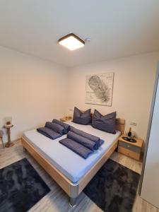 een slaapkamer met een bed met blauwe kussens bij Apart Bubendorfer in Lermoos