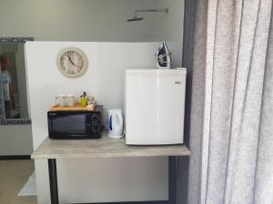 a counter with a microwave and a small refrigerator at The Guesthouse Klerksdorp in Klerksdorp
