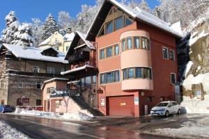 un grand bâtiment avec une voiture garée devant lui dans l'établissement B&B Hotel Heimgartl, à Innsbruck