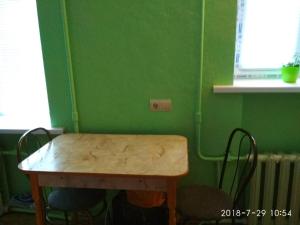 una mesa de madera en una habitación con una pared verde en министудия, в которой есть абсолютно всё, en Cherníhiv