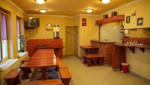 a restaurant with wooden tables and benches in a room at Pajkos Póni Vendégház in Miskolc