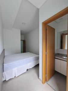 a bedroom with a bed and a mirror at Apartamento Ubatuba Reserva DNA in Ubatuba