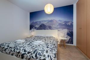 ein Schlafzimmer mit einem Bett mit einem Wandbild der Berge in der Unterkunft APARTAMENTO RANSOL in Ransol