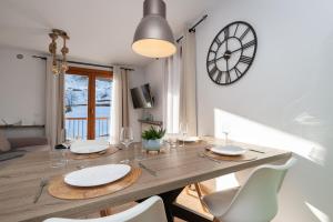 uma mesa de jantar com cadeiras e um relógio na parede em APARTAMENTO RANSOL em Ransol