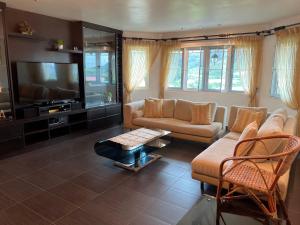 un soggiorno con divano e TV di MAGICAL HOMESTAY CAMERON HIGHLANDS a Cameron Highlands