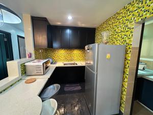 cocina con nevera de acero inoxidable y azulejos amarillos en MAGICAL HOMESTAY CAMERON HIGHLANDS en Cameron Highlands