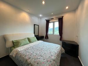 Un pat sau paturi într-o cameră la MAGICAL HOMESTAY CAMERON HIGHLANDS
