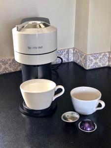 a coffee maker and two cups on a counter at Le Pigeonnier Gite in Verrières