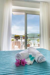 a hotel room with a bed with towels and a window at Hotel Carillon in Baveno