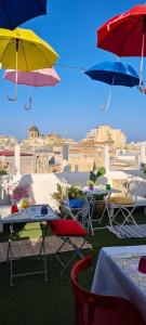 un groupe de tables et de parapluies sur un toit dans l'établissement Due Passi Dal Centro, à Marsala