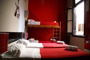 a bedroom with two bunk beds and a red wall at Hostel La Casona de Don Jaime 2 and Suites HI in Rosario