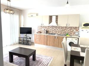 a kitchen with a table and a stove top oven at Comfortable One-Bedroom Apartment near the Sea and Casino Merit Park Sel 2-6 in Kyrenia