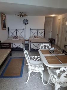 a room with two beds and a table and chairs at Las Torres Gemelas - Torres Gemelas Apartamento 810 in Acapulco