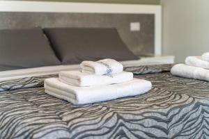 a pile of towels sitting on top of a bed at La Perla delle Dune (Sul Mare) in Porto Cesareo +64 photos