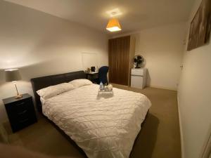 a bedroom with a bed and a table in it at ASHMINA HOLIDAY LET with Free onsite Parking for SMALL VANS and cars only in Milton Keynes