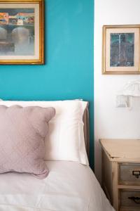 a bed with a blue wall and a picture above it at Villa Lorelei in Massa Lubrense