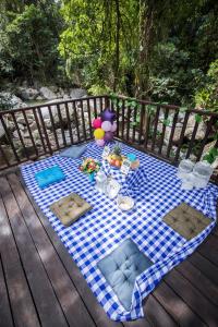 a picnic table on a deck with a blue and white checkered blanket at Hotel MadreSierra Parque Tayrona in Calabazo