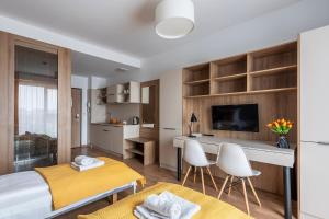 1 dormitorio con 1 cama y escritorio con sillas en City Break Wolska Aparthotel en Varsovia