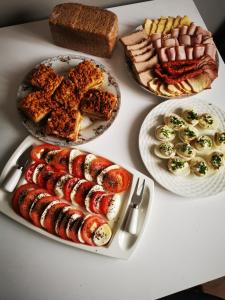 a white table with plates of food on it at Siedlisko Pod Pucharami in Hoczew