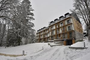 a building on a snow covered road in front at Apartment Tatry mountain in Tatranska Strba