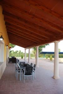 a patio with a table and chairs under a wooden ceiling at Casa Rural Tablas de Daimiel in Daimiel
