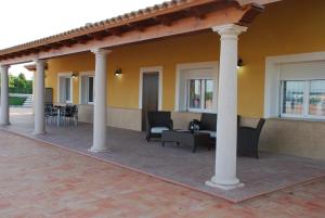 a patio with chairs and tables and columns at Casa Rural Tablas de Daimiel in Daimiel