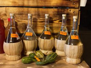 four bottles of wine sitting on a table with cucumbers at Eden By the Mountain in Bran