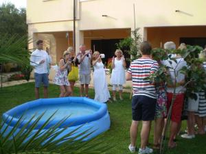 a group of people standing around a blue inflatable pool at Apartments Tare, Electric Car Refill in Vodice +48 photos
