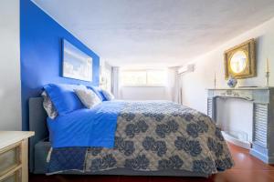 a blue bedroom with a bed and a fireplace at Villa Lorelei in Massa Lubrense