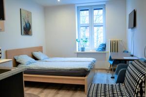 a bedroom with a bed and a desk and a window at One-room apartment on Ogarna St in the Old Town in Gdańsk