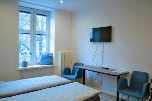 a bedroom with two beds and a desk and a television at One-room apartment on Ogarna St in the Old Town in Gdańsk