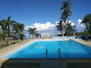 a large swimming pool with palm trees in the background at Hideaway Resort Victoria secret hideaway resort in Maraat
