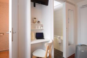 un pequeño baño con un ordenador portátil en un estante en Hotel Arc-En-Ciel Colmar Contact Hotel, en Colmar