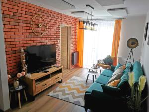 Televízia a/alebo spoločenská miestnosť v ubytovaní APARTAMENT NA WZGÓRZU