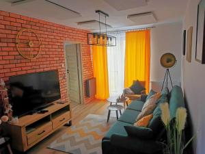 Televízia a/alebo spoločenská miestnosť v ubytovaní APARTAMENT NA WZGÓRZU