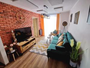 Televízia a/alebo spoločenská miestnosť v ubytovaní APARTAMENT NA WZGÓRZU