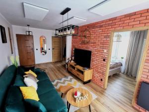 Televízia a/alebo spoločenská miestnosť v ubytovaní APARTAMENT NA WZGÓRZU