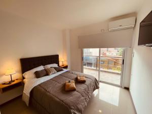 ein Schlafzimmer mit einem großen Bett und einem großen Fenster in der Unterkunft Departamento frente al lago en Villa Carlos Paz in Villa Carlos Paz