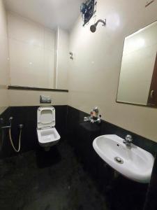 a bathroom with a sink and a toilet and a mirror at BHIMAS INN -Puratchi Thalaivar Dr M G Ramachandran Central Railway Station Chennai in Chennai