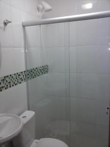 a bathroom with a shower and a toilet and a sink at Hotel Jerusalém 2 in Goiânia