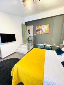 sypialnia z żółtym łóżkiem i telewizorem z płaskim ekranem w obiekcie Palazzina300 w mieście Treviso