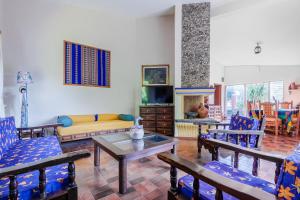 Casa Jacobina Tepoztlán في تيبوزتلان: غرفة معيشة مع كراسي زرقاء وأريكة
