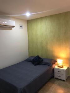 a bedroom with a bed and a lamp on a night stand at Casa Antonella SM in Santa Marta
